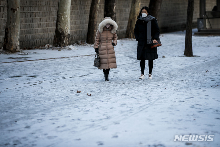 [서울=뉴시스] 정병혁 기자 = 추운 날씨가 이어지고 있는 지난 28일 오전 서울 중구 시청역 인근에서 시민들이 눈 내린 길을 걷고 있다. 2022.12.28. jhope@newsis.com