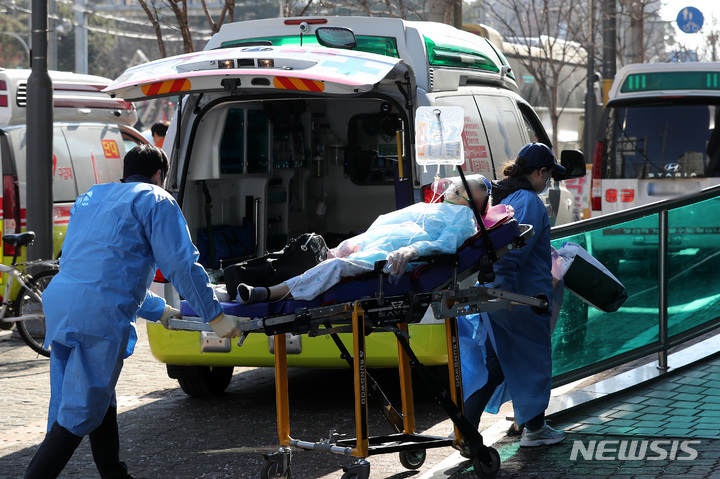 [서울=뉴시스] 백동현 기자 = 지난 28일 오전 서울 광진구에 위치한 코로나19거점전담병원인 혜민병원 앞에서 구급 대원들이 환자를 이송하고 있다. 2022.12.29. livertrent@newsis.com