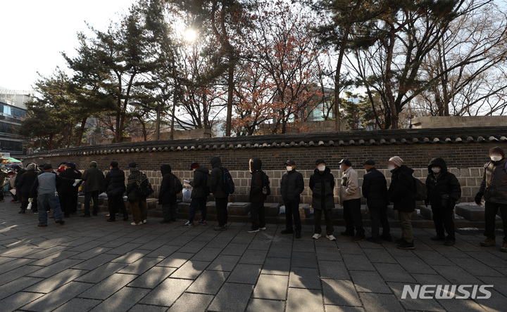 [서울=뉴시스] 조수정 기자 = 종일 영하권 강추위를 보인 지난해 12월29일 서울 종로구 탑골공원 옆 원각사 무료급식소에서 어르신들이 점심 배식을 받기 위해 줄서 기다리고 있다. 2022.12.29. chocrystal@newsis.com