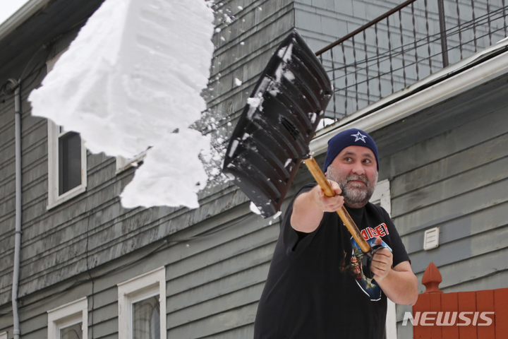 [버팔로=AP/뉴시스] 29일(현지시간) 미 뉴욕주 버팔로에서 반팔 차림의 한 주민이 눈을 치우고 있다. 40여 년만의 최악의 눈 폭풍이 지나간 후 주민들은 제설 작업을 이어가고 있다. 2022.12.30.