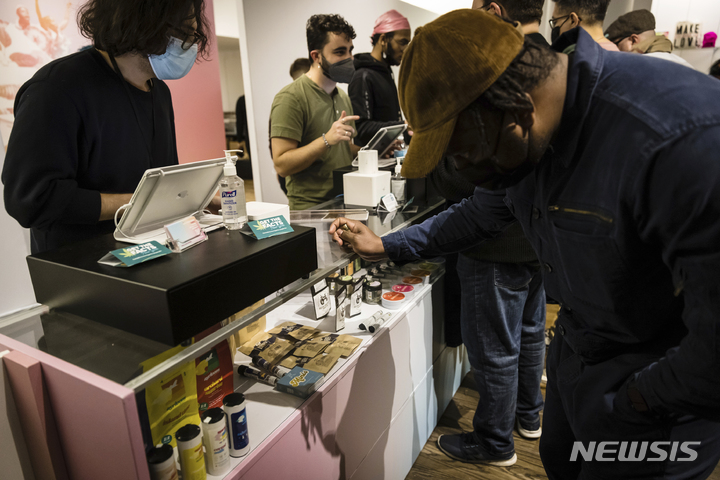 [뉴욕=AP/뉴시스] 29일(현지시간) 미 뉴욕주 뉴욕에서 처음으로 문을 연 기호용 마리화나 판매점에서 한 남성이 마리화나 제품을 고르고 있다. 뉴욕주의 허가를 받아 주 최초로 마리화나 판매점을 개장한 비영리단체 '하우징 웍스'(Housing Works)는 당분간 휴무 없이 주 7일 운영한다고 밝혔다. 2022.12.30.