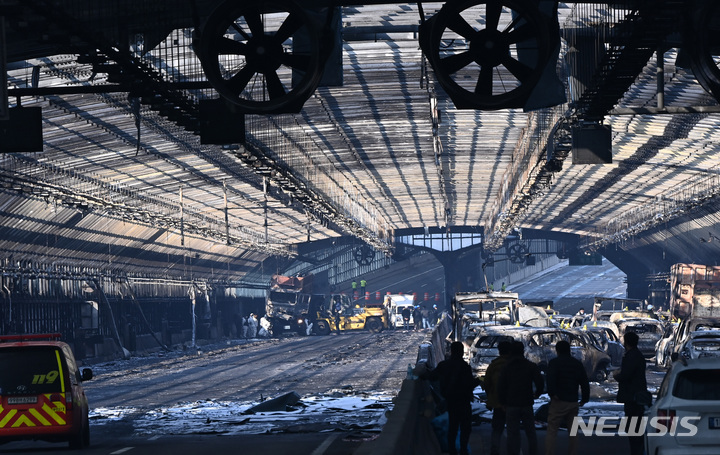[과천=뉴시스] 김종택 기자 = 5명의 사망자가 발생한 경기도 과천시 제2경인고속도로 갈현고가교 방음터널 화재 현장에서 30일 경찰과 소방, 국과수 등 관계자들이 화재 발생 당시 최초 불이 난 트럭을 감식하고 있다. 2022.12.30. jtk@newsis.com