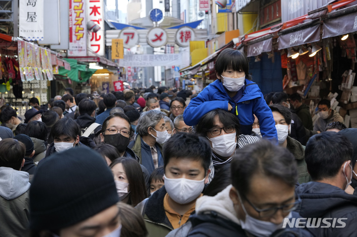 [도쿄=AP/뉴시스] 30일 일본 도쿄에서 연말연시를 맞아 마스크 착용·미착용 시민들이 유명 쇼핑가에서 쇼핑하고 있다. 일본은 급증하는 코로나19 감염에 대한 긴급 조치로 중국발 모든 입국자에 대해 코로나19 검사를 요구하기로 했다. 2022.12.30.