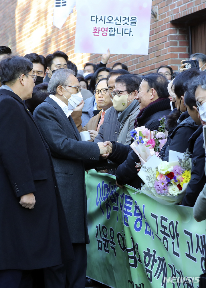 [서울=뉴시스] 최진석 기자 = 신년 특별사면으로 사면·복권된 이명박 전 대통령이 30일 서울 강남구 자택에 도착해 지지자들과 인사를 나누고 있다. 2022.12.30. myjs@newsis.com