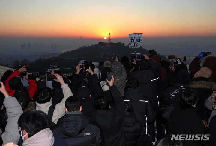 [서울=뉴시스] 조성우 기자 = 2023년 계묘년 새해 첫 날인 1일 오전 서울 중구 남산공원에서 시민들이 일출을 보고 있다. 2023.01.01. xconfind@newsis.com
