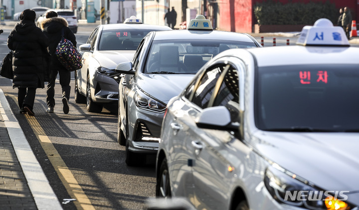 [서울=뉴시스] 정병혁 기자 = 1일 오전 서울 중구 서울역에서 시민들이 택시를 타고 있다. 서울시에 따르면 2월1일부터 택시 요금이 오른다. 승객들은 1000원 오른 4800원의 기본요금을 지불해야 한다. 기본 거리는 현행 2㎞에서 1.6㎞로 400m 줄어든다. 20%로 일률 적용되던 심야 할증률이 지난해 12월1일자로 오후 11시~오전 2시 기준 40%까지 늘어난데 이어 기본요금까지 상승하면서 지출액은 훨씬 늘게 됐다. 2023.01.01. jhope@newsis.com