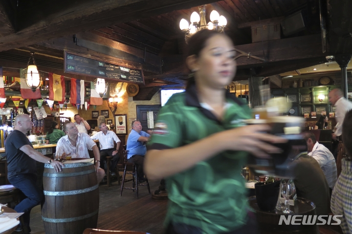 [두바이=AP/뉴시스]지난 2016년 6월22일 아랍에미레이트 두바이의 한 레스토랑에서 종업원이 고객에게 맥주를 제공하는 모습. 2023.01.01.