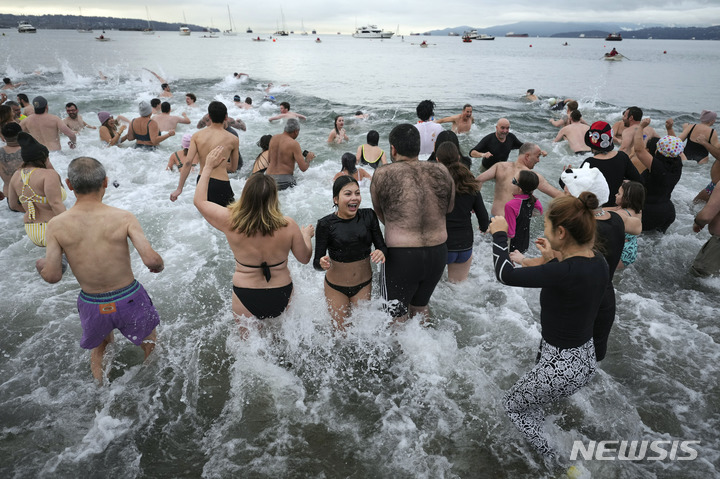 [밴쿠버=AP/뉴시스] 1일(현지시간) 캐나다 브리티시컬럼비아주 밴쿠버에서 북극곰 수영대회가 열려 참가자들이 잉글리시 베이에 뛰어들고 있다. 코로나19 대유행으로 중단됐던 북극곰 수영대회가 2020년 이후 처음으로 재개됐다. 2023.01.03.