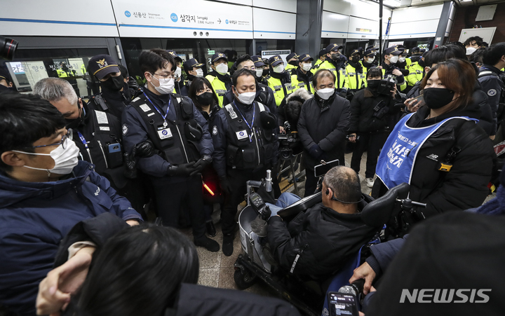 [서울=뉴시스] 김근수 기자 = 전국장애인차별철폐연대(전장연) 회원들이 2일 오전 서울 지하철 4호선 삼각지역에서  장애인 권리 예산 보장을 촉구하는 출근길 지하철 탑승 시위에서 탑승을 시도하고 있다. 전장연은 법원 조정안에 맞춰 5분 내 탑승을 수용하겠다고 밝혔다. 2023.01.02. ks@newsis.com