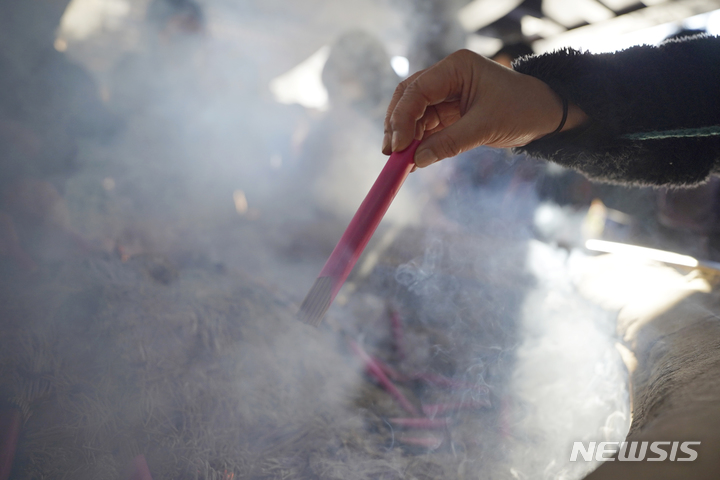 [도쿄=AP/뉴시스] 2일 일본 도쿄 근처 가와사키에 있는 다이시 사찰에서 새해 첫 신사나 사찰을 방문해 '하츠모데'를 하려는 방문객이 향 묶음을 태우며 행운을 기원하고 있다. 2023.01.04.