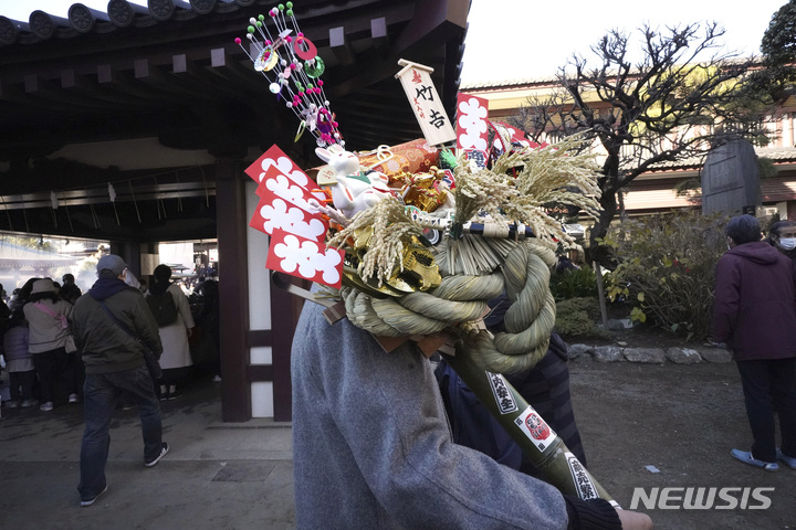 [도쿄=AP/뉴시스] 2일 일본 도쿄 근처 가와사키에 있는 다이시 사찰에서 방문객이 '쿠마데(갈퀴)' 모양의 행운 부적을 들고 다니고 있다. 많은 방문객들은 '하츠모데'에 신사나 사원을 새해 첫날 방문해 행운을 기원한다. 2023.01.04.