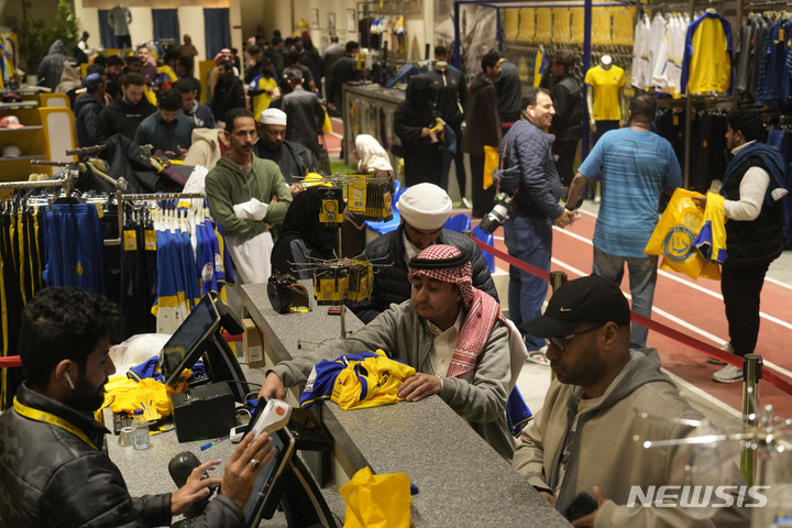 [리야드=AP/뉴시스] 2일(현지시간) 사우디아라비아 리야드의 '알 나스르' 구단 매장에서 축구팬들이 크리스티아누 호날두의 등번호와 이름이 적힌 유니폼을 사기 위해 줄 서 있다. 호날두는 사우디의&nbsp; '알 나스르'로 2025년 여름까지 연봉 2700억 원에 입단했다. 2023.01.03.