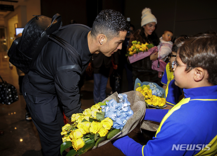 [리야드=AP/뉴시스] 크리스티아누 호날두가 2일(현지시간) 사우디아라비아 리야드 국제공항에 도착해 화동들의 꽃다발을 받고 있다. 호날두는 사우디의 가장 성공적인 팀인 '알 나스르'로 연봉 2700억 원에 입단했다. 2023.01.03.