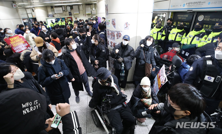 [서울=뉴시스] 조수정 기자 = 3일 오전 서울 지하철 4호선 동대문역사문화공원역 승강장에서 전국장애인차별철폐연대(전장연) 회원들이 254일차 장애인 권리예산 입법 쟁취 지하철 선전전을 위해 탑승하려던 중 저지하는 서울지하철공사 직원 및 경찰들에게 가로막혀 있다. 전장연은 이날 4호선 성신여대입구 역에서 탑승했다가 동대문역사문화공원 역에서 하차했다. 다시 탑승하고 삼각지역으로 향해 집회를 이어가려고 했으나 교통공사와 경찰의 탑승 저지로 이동하지 못하고 있다. 2023.01.03. chocrystal@newsis.com