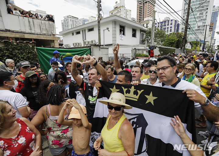 [산투스=AP/뉴시스] 3일(현지시간) 브라질 상파울루 외곽 산투스에서 시민들이 묘지로 향하는 '축구 황제' 펠레의 장례 행렬을 지켜보고 있다. 펠레는 아버지와 형제가 묻힌 '네크로폴 에큐메니카' 공동묘지에 안장됐다. 14층 높이의 이 묘지는 세계에서 가장 높은 공동묘지로 기네스북에 올라 있다. 2023.01.04.
