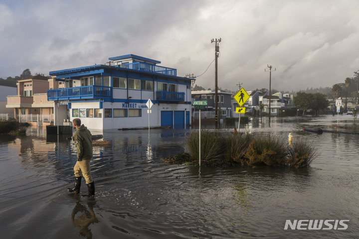 [캘리포니아=AP/뉴시스] 한 남성이 5일(현지시간) 캘리포니아 앞토스에서 침수된 길을 걸어가고 있다.&nbsp; 2023.01.05.