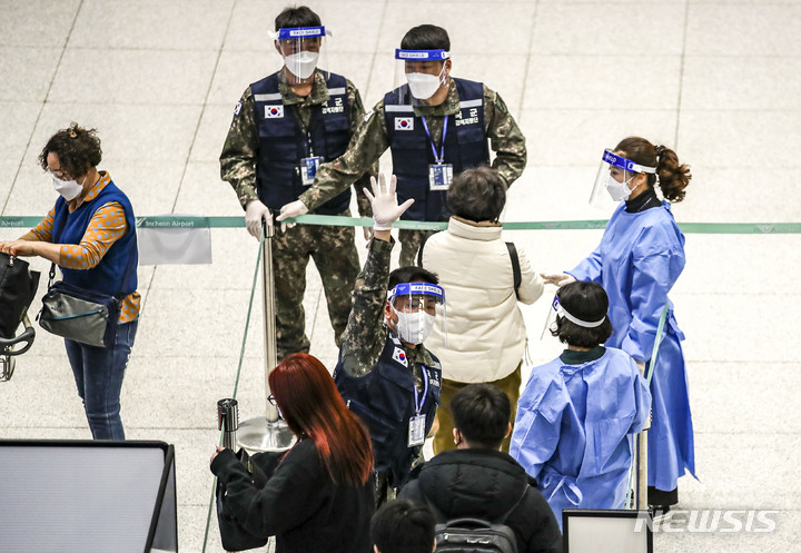 [인천공항=뉴시스] 정병혁 기자 =  중국발 입국자 코로나19 검사 의무화가 시행중인 6일 오후 인천국제공항 제2여객터미널에서 선양발 입국자들이 검역 지원 육군 장병들과 PCR검사 대기장소로 이동하고 있다. 2023.01.06. jhope@newsis.com