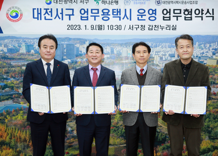 [대전=뉴시스] 조명휘 기자 = 대전 서구와 하나은행, 대전시개인택시운송사업조합, 택시운송사업조합이 9일 구청에서 업무용 택시 도입을 위한 업무협약을 체결하고 있다. (사진= 서구청 제공) 2023.01.09. photo@newsis.com *재판매 및 DB 금지