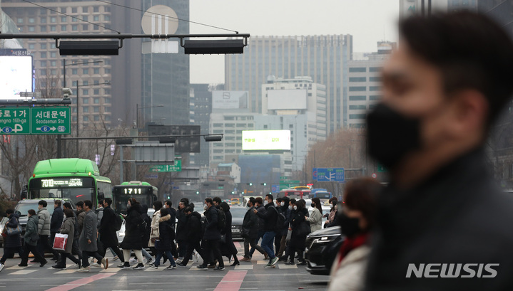 [서울=뉴시스] 김진아 기자 = 서울 및 수도권 미세먼지 상태가 '나쁨 수준'을 보이고 있는 9일 서울 광화문네거리에서 마스크를 쓴 시민들이 출근하고 있다. 2023.01.09. bluesda@newsis.com