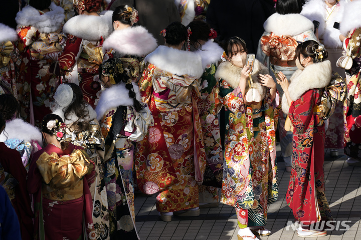 [요코하마=AP/뉴시스] 기모노 차림의 여성들이 9일 도쿄 인근 요코하마에서 20세가 된 것을 축하하는 성년의 날 공식 행사에 입장하기 위해 줄을 서 있다. 일본의 각 지방 자치 단체는 매년 1월 둘째 주 월요일마다&nbsp; 성인이 된 청년들을 축하하는 행사를 개최한다. 일본은 2022년 성인의 나이를 20세에서 18세로 낮췄다. 2023.01.09.<font _mstmutation="1" _msthash="178997" _msttexthash="1269740758"></font>