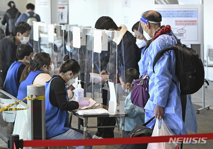 [나리타=교도·AP/뉴시스]지난 8일 중국 상하이발 승객들이 일본 수도 도쿄 인근 나리타공항에 도착 직후 코로나19 음성 판정을 받은 증명서를 제시하고 있다. 