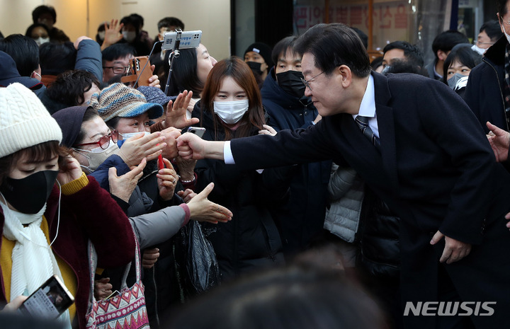 [인천=뉴시스] 추상철 기자 = 이재명 더불어민주당 대표가 11일 오후 인천 남동구 모래내시장을 방문해 지지자와 주먹을 마주치고 있다. 2023.01.11. scchoo@newsis.com