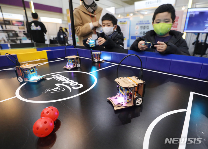 [서울=뉴시스] 김진아 기자 = 12일 서울 강남구 코엑스에서 열린 제20회 대한민국 교육박람회에서 어린들이 AI·코딩로봇을 이용한 축구게임을 체험하고 있다. 2023.01.12. bluesda@newsis.com