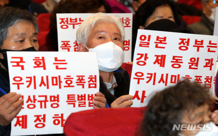 [서울=뉴시스] 추상철 기자 = 일제강제징용 피해자 유족이 12일 오전 서울 여의도 국회에서 열린 '일제강제징용 해법 논의를 위한 공개토론회'에서 피켓을 들고 참석해 있다. 2023.01.12. scchoo@newsis.com