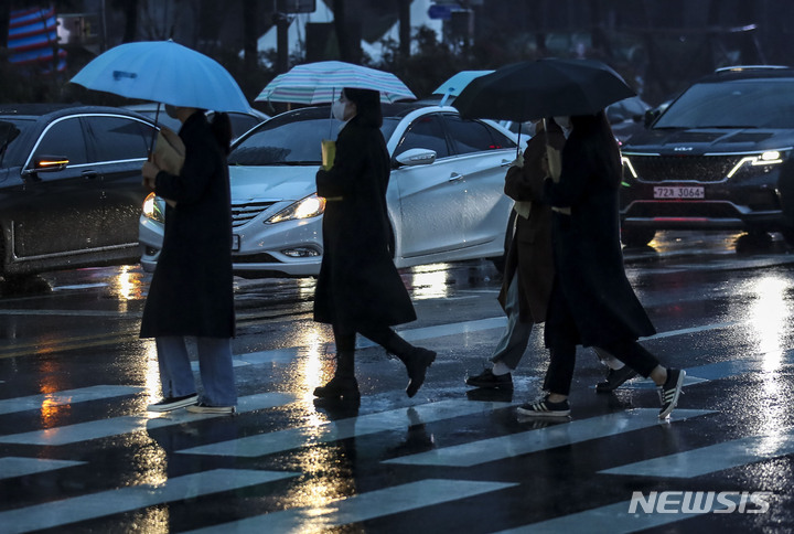 [서울=뉴시스] 정병혁 기자 = 13일 오전 종로구 광화문네거리에서 우산을 쓴 시민들이 이동하고 있다. 2023.01.13. jhope@newsis.com