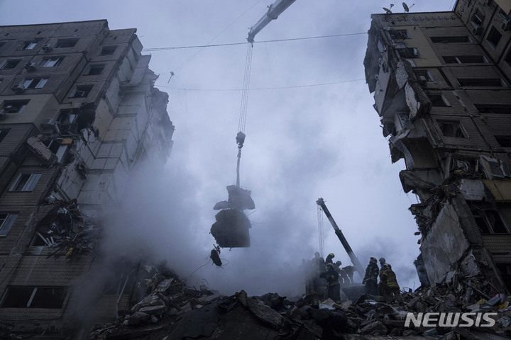 [드니프로=AP/뉴시스] 15일(현지시간) 우크라이나 남동부 도시 드니프로에서 구조대가 러시아군의 로켓 공격으로 파괴된 아파트 건물 잔해를 치우고 있다. 이 공격으로 인한 사망자 숫자는 25명으로 늘어났으며 볼로디미르 젤렌스키 우크라이나 대통령은 러시아의 드니프로 아파트 단지 미사일 공격을 '테러'로 규정하면서 "러시아인들이 비겁하게 침묵하고 있다"라고 비난했다. 2023.01.16.