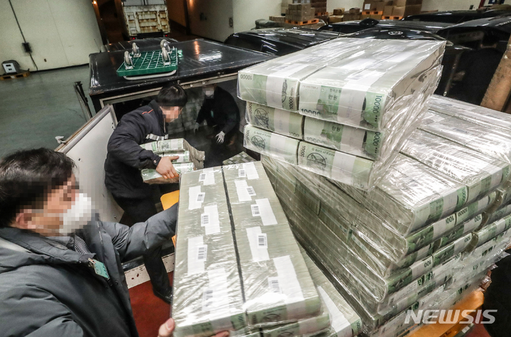 [서울=뉴시스] 사진공동취재단 = 설 명절을 일주일 앞둔 16일 서울 강남구 한국은행 강남본부에서 현금운송 관계자들이 시중은행에 공급될 설 자금 방출 작업을 하고 있다. 1000장씩 묶인 5만원권과 1만원권 등의 지폐들은 각 지역으로 옮겨진다. 2023.01.16. photo@newsis.com