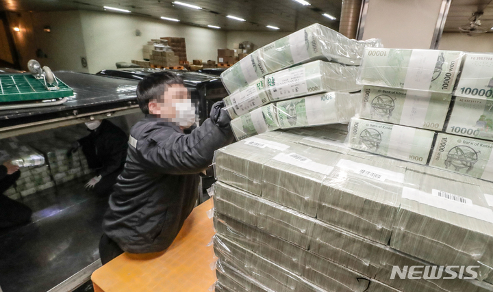 [서울=뉴시스] 사진공동취재단 = 설 명절을 일주일 앞둔 16일 서울 강남구 한국은행 강남본부에서 현금운송 관계자들이 시중은행에 공급될 설 자금 방출 작업을 하고 있다. 1000장씩 묶인 5만원권과 1만원권 등의 지폐들은 각 지역으로 옮겨진다. 2023.01.16. photo@newsis.com