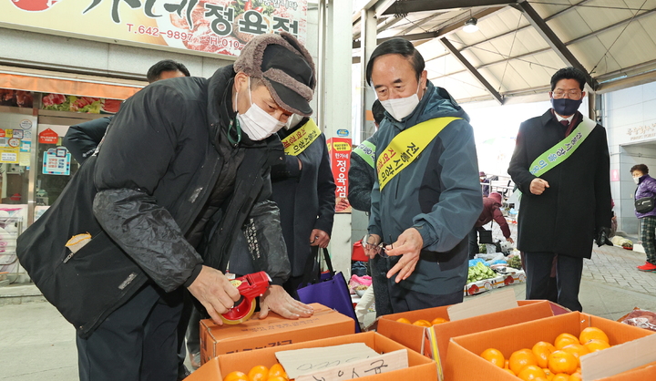 설망지 전통시장 장보기에 나선 심민 임실군수(가운데)가 임실시장에서 상인들과 인사를 나누며 과일을 구입하고 있다. *재판매 및 DB 금지