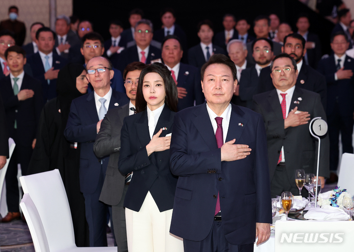 [아부다비=뉴시스] 전신 기자 = 아랍에미리트(UAE)를 국빈 방문 중인 윤석열 대통령과 부인 김건희 여사가 16일 오후(현지시간) 아부다비 에티하드타워에서 열린 동행 경제인과의 만찬 간담회에서 국기에 대한 경례를 하고 있다. 2023.01.17. photo1006@newsis.com