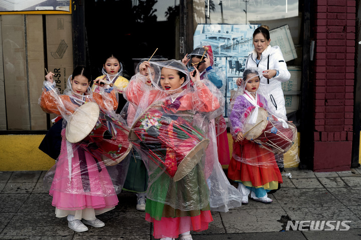 [로스앤젤레스=AP/뉴시스] 마틴 루터 킹 주니어(MLK)의 날인 16일(현지시간) 미 캘리포니아주 로스앤젤레스에서 우비를 입은 한인 무용학원 학생들이 퍼레이드 준비를 하고 있다. 미국은 흑인 민권 운동가 킹 목사를 기리기 위해 매년 1월 셋째 주 월요일을 'MLK의 날'로 지정해 연방 공휴일로 기념한다. 2023.01.17.