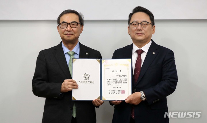 [서울=뉴시스] 김선웅 기자 =&nbsp; 제52대 대한변호사협회장으로 당선된 김영훈(오른쪽) 변호사가 17일 서울 서초구 대한변협회관에서 열린 당선증 교부식에서 조동용 대한변협 선관위원장으로부터 당선증을 받고 있다. 2023.01.17. mangusta@newsis.com