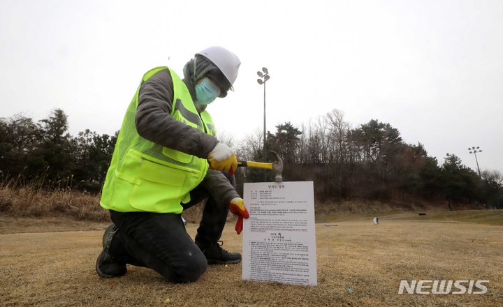 [인천=뉴시스] 최동준 기자 = 17일 인천 중구 스카이72 바다코스에서 인천지방법원 관계자가 골프장 운영권 반환 강제집행을 알리는 팻말을 필드에 박고 있다. (공동취재사진) 2023.01.17. photo@newsis.com