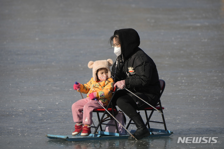 [베이징=AP/뉴시스] 중국 인구가 지난해에도 감소한 가운데 중국 인구학자들이 출산 욕구 감소, 코로나19 등을 원인으로 지목했다. 사진은 지난해 1월17일 중국 베이징의 공원 연못에서 한 모녀가 썰매를 타는 모습. 2024.01.17.