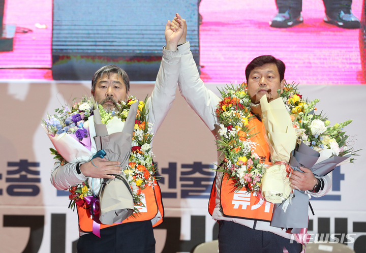 [서울=뉴시스] 고승민 기자 = 지난 17일 서울 잠실실내체육관에서 열린 한국노총 2023년 정기선거인대회에서 기호2번 김동명 위원장 후보, 류기섭 사무총장 후보가 2차 투표로 과반 1860표를 얻어 당선, 손을 들어 보이고 있다. 2023.01.17. kkssmm99@newsis.com