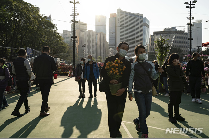 [홍콩=AP/뉴시스] 홍콩섬 코즈웨이 베이에 있는 화훼시장에서 18일 시민들이 구입한 꽃을 들고 걸어가고 있다. 2023.01.19 