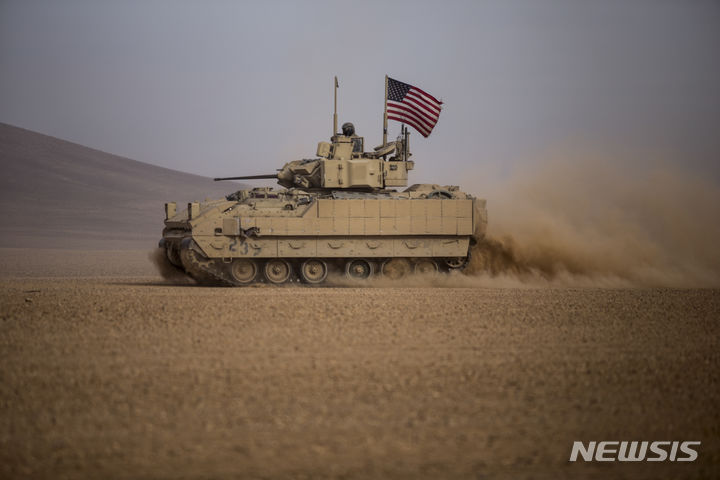 [디르 에조르(시리아)=AP/뉴시스] 미군 중부사령부(CENTCOM) 소속 병력이 시리아 알레포에서 수니파 무장단체 이슬람국가(IS) 고위 지도자 등 3명을 사살했다고 25일(현지 시간) 미군이 밝혔다. 사진은 2021년 12월 8일 시리아 북동부 디르 에조르의 사막에서 미군의 브래들리 장갑차가 시리아민주군(SDF)과 합동훈련을 펼치는 모습. 2025.07.26. 
