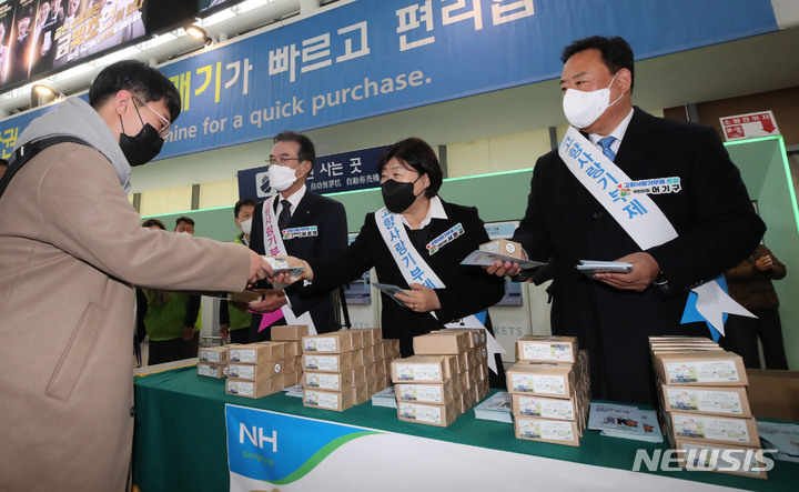 [서울=뉴시스] 권창회 기자 = 이성희(왼쪽부터) 농협중앙회장, 서영교, 어기구 더불어민주당 의원이 지난 1월19일 오전 서울 중구 서울역 대합실에서 설맞이 고향사랑기부제 홍보 캠페인으로 시민들에게 떡을 나눠주고 있다. 2023.01.19. kch0523@newsis.com