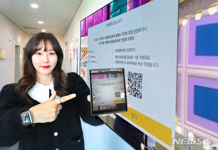 [서울=뉴시스]LG유플러스는 고객경험 혁신을 위해 업계 최초로 U+tv에 QR코드 와이파이(WiFi) 접속 기능을 적용했다고 25일 밝혔다. 사진은 LG유플러스 직원이 U+tv 속 QR코드를 스마트폰 카메라로 촬영해 WiFi를 연결하고 있는 모습. (사진=LG유플러스 제공)