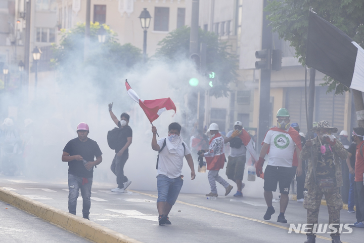 [페루=AP/뉴시스] 페루 리마에서 시위대가 2023년 1월 24일 최루탄 가스 속에서 행진하며 볼루아르테 현 대통령의 사임과 축출된 페드로 카스티요 전 대통령의 석방 및 즉각적인 선거실시 등을 요구하고 있다. 2025.03.05. 