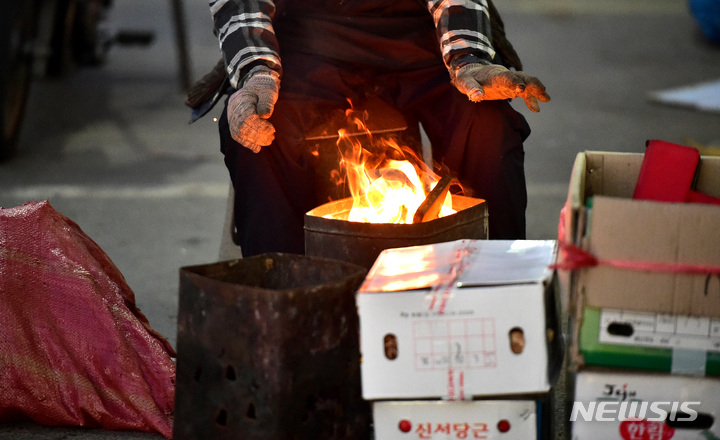 [대구=뉴시스] 이무열 기자 = 전국에 기온이 뚝 떨어지며 추운날씨를 보인 지난 25일 오전 대구 북구 칠성시장에서 한 상인이 모닥불을 쬐고 있다. 2023.01.25. lmy@newsis.com