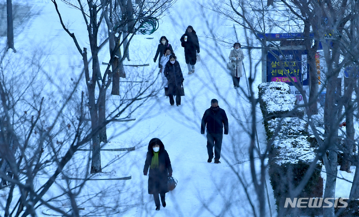 [광주=뉴시스] 김혜인 기자 = 한파특보가 내려진 25일 오전 광주 서구 치평동 한 도로에서 시민들이 눈길을 걷고 있다. 2023.01.25. hyein0342@newsis.com