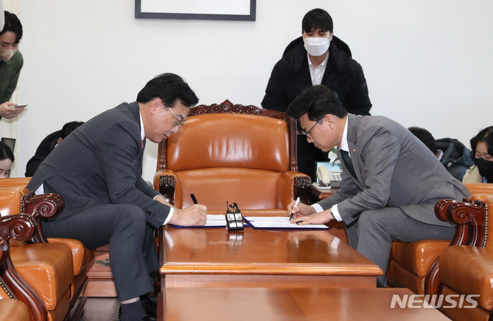 [서울=뉴시스] 전진환 기자 = 송언석 국민의힘 원내수석부대표와 진성준 더불어민주당 원내수석부대표가 25일 오후 서울 여의도 국회 운영위원장실에서 1~2월 임시회 의사일정에 합의 후 합의문에 서명하고 있다. 2023.01.25. amin2@newsis.com
