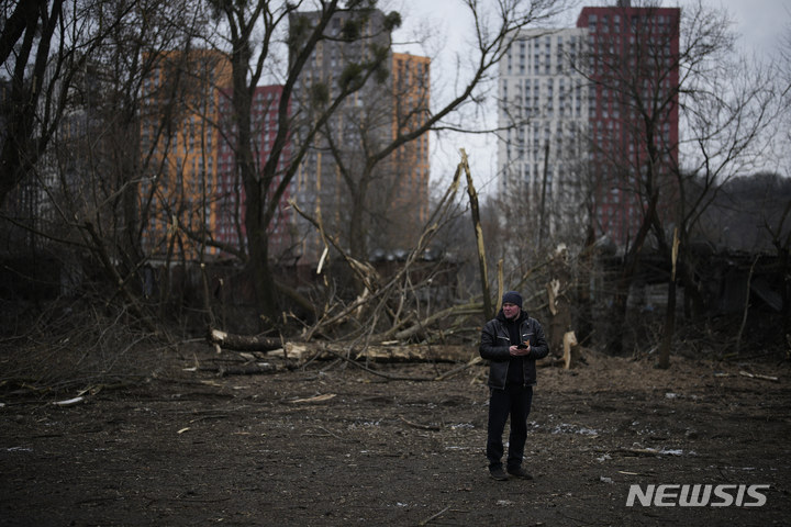 [키이우=AP/뉴시스] 한 남성이 26일(현지시간) 우크라이나 키이우에서 미사일 공격을 받은 구역에 서 있다. 2023.01.27.