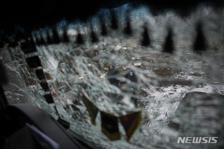 [흘레바하=AP/뉴시스] 26일(현지시간) 우크라이나 키이우주 흘레바하에서 러시아군의 로켓 공격으로 파괴된 트럭 유리 사이로 한 주민이 지나가고 있다. 미국과 독일이 우크라이나에 주력 전차를 지원하기로 한 다음 날 러시아는 대대적인 공습을 가했다. 2023.01.27.