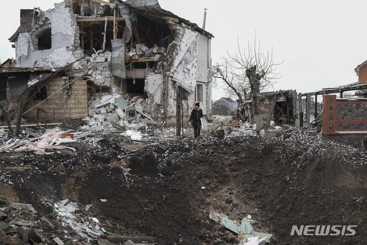 [흘레바하=AP/뉴시스] 26일(현지시간) 우크라이나 키이우주 흘레바하에서 한 주민이 러시아군의 로켓 공격으로 생겨난 대규모 포격 구덩이를 바라보고 있다. 미국과 독일이 우크라이나에 주력 전차를 지원하기로 한 다음 날 러시아는 대대적인 공습을 가했다. 2023.01.27.